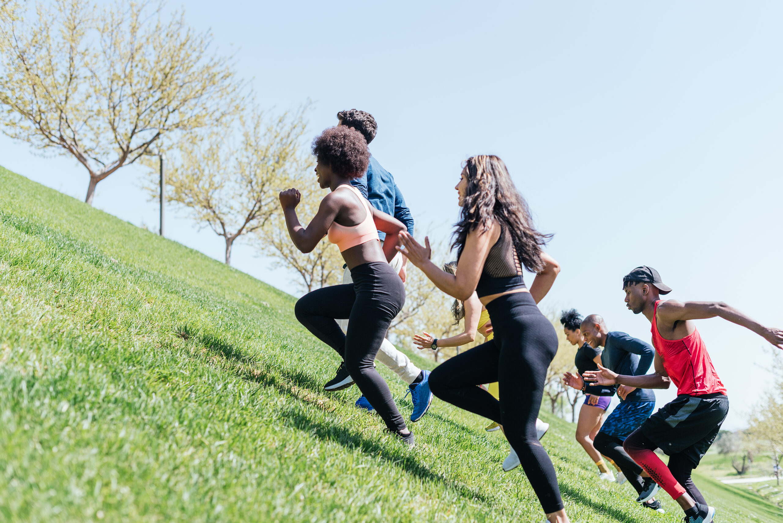People running up a grassy hill.