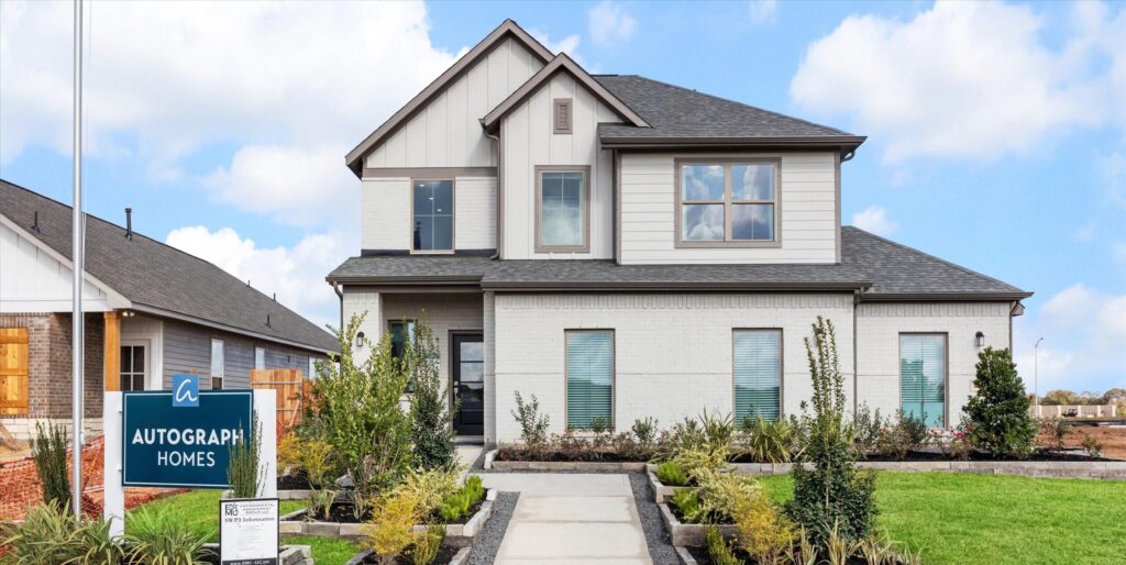 Two-story modern house with green lawn and Autograph Homes sign by Houston home builders.