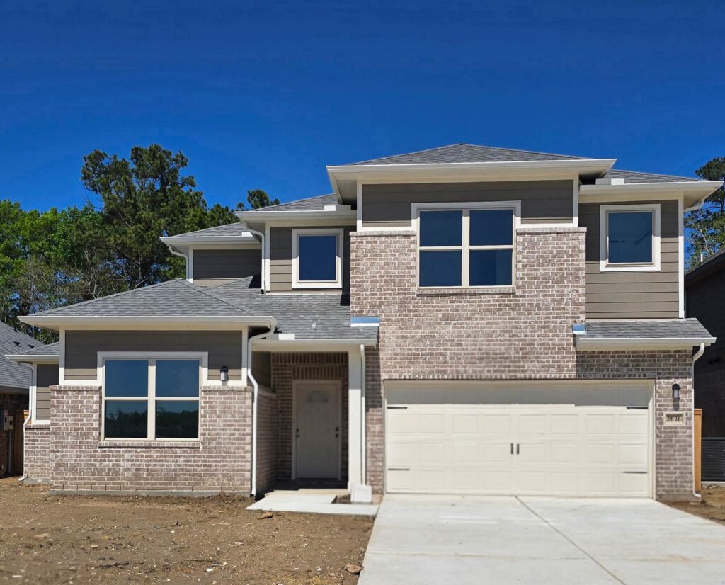 Two-story modern brick house with double garage built by Houston home builders Autograph Homes.