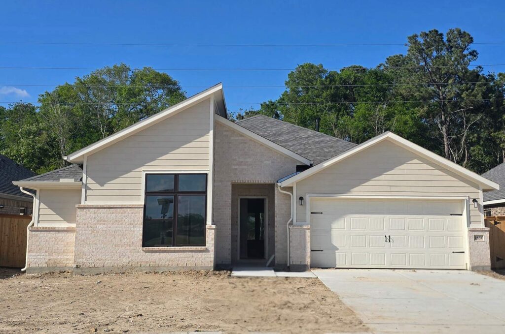 Built by Houston home builders Autograph Homes a single-story white brick house with a double garage.