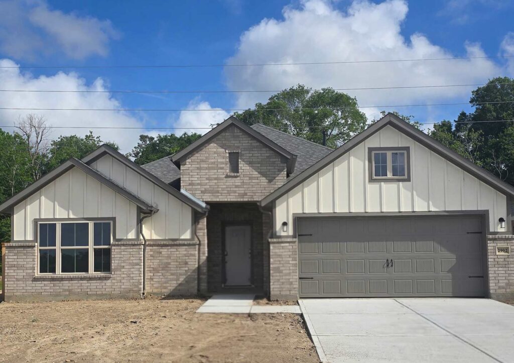 Built by Houston home builders Autograph Homes a single-story house with brick and siding exterior and double garage.